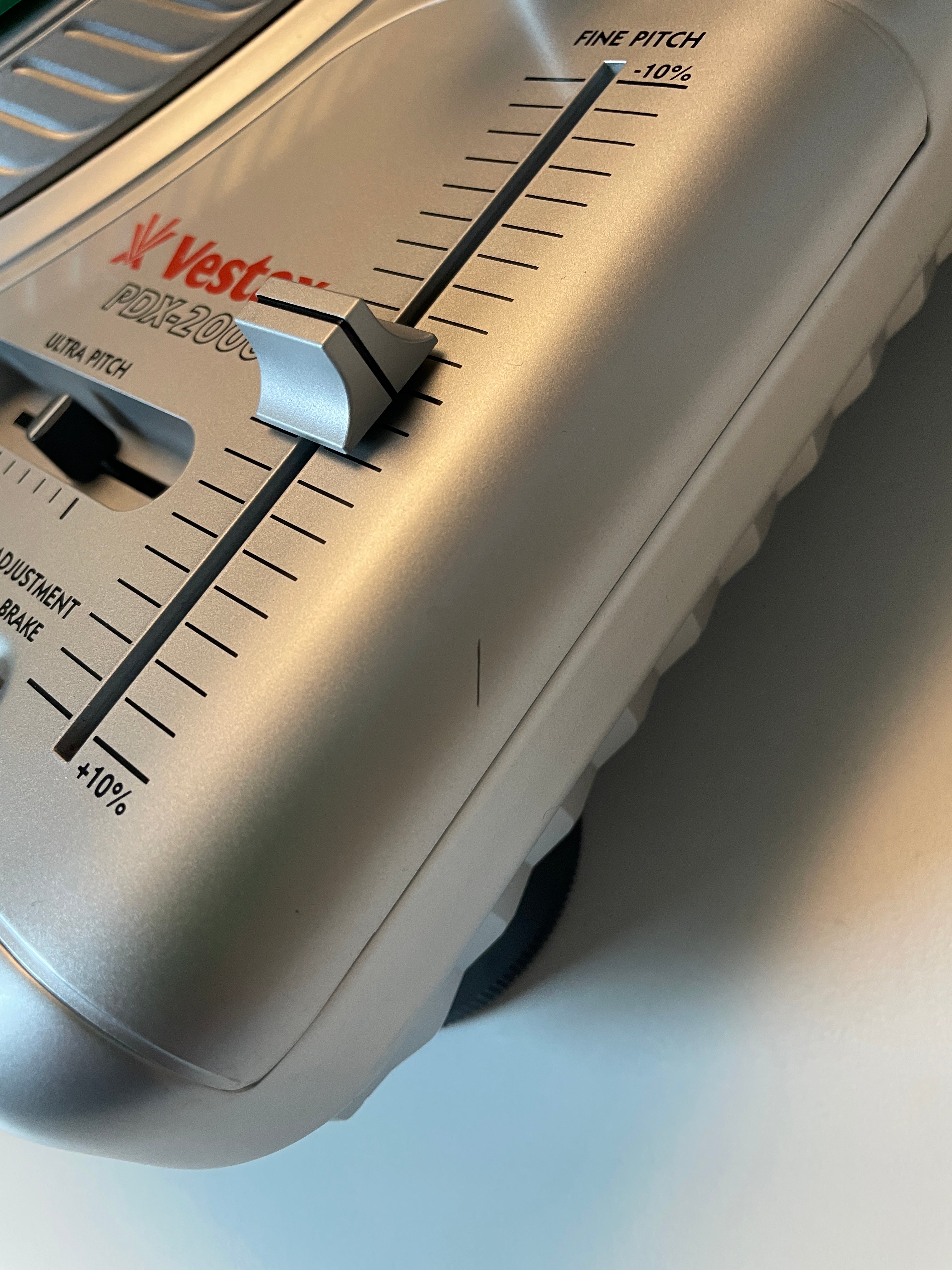 Close-up of a silver  Vestax PDX-2000 vector pitch slide control unit, showing the adjustment dial and markings.