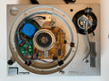 Open face of a Technics turntable showing internal components including the plinth, tonearm, circuit boards, and speaker assembly.