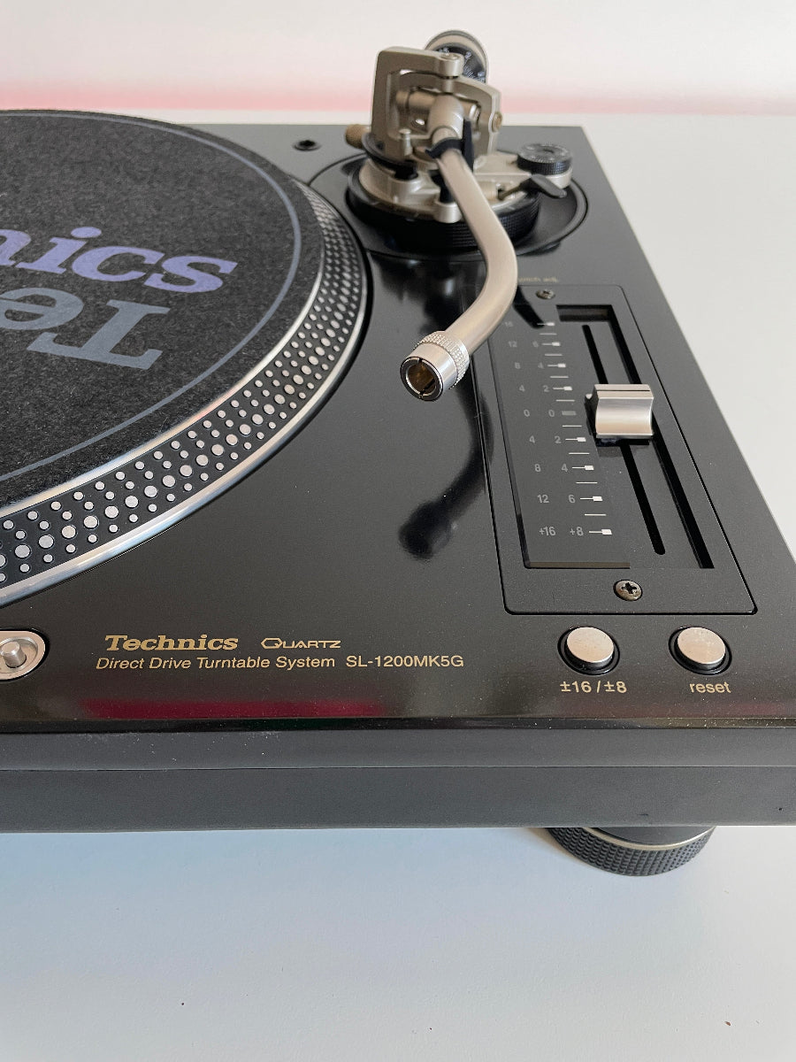 Close-up of a Technics turntable with visible branding on a white background