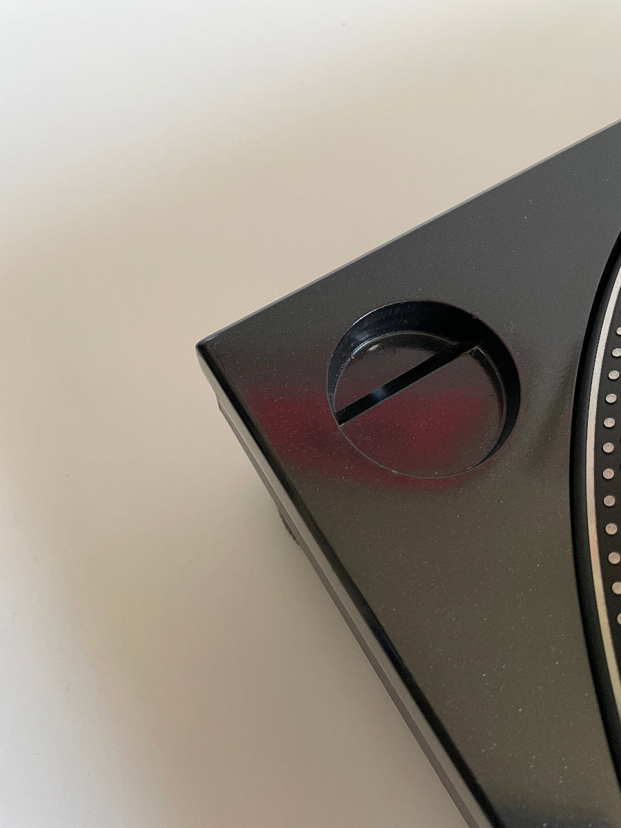 Close-up of a black electronic device on a beige surface
