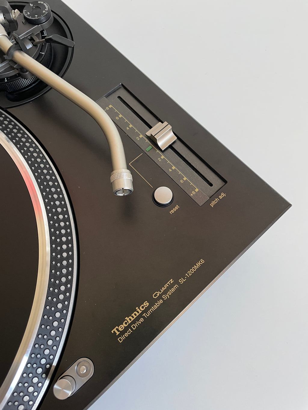 Close-up of a turntable with visible brand name on a light gray background