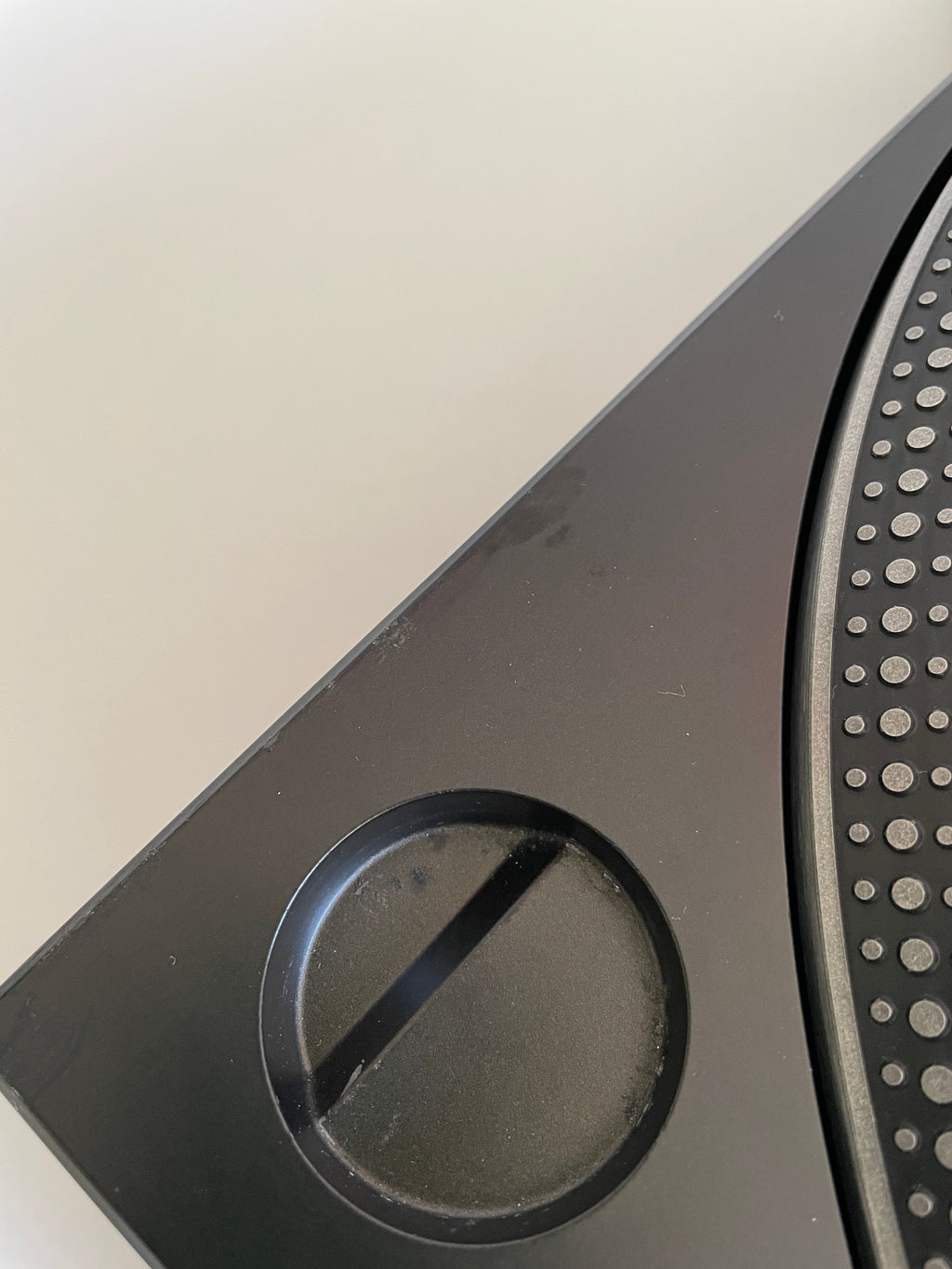 Close-up of a black electronic device with a circular cutout on a white background