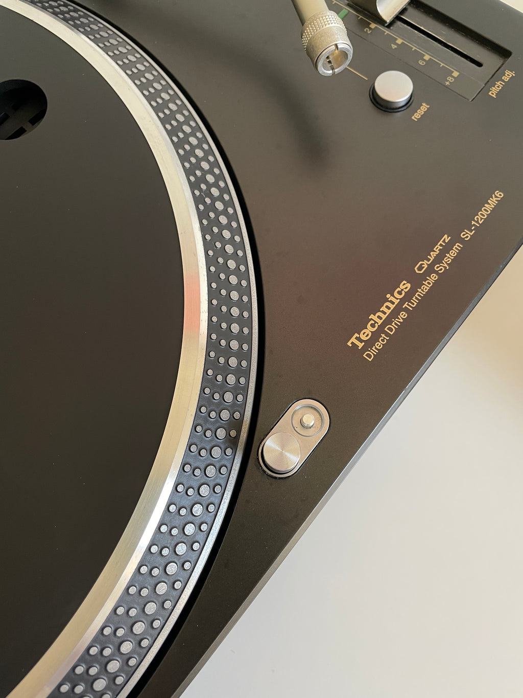 Close-up of a turntable with 'Technics' branding on a white background