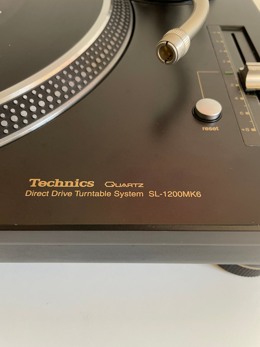Close-up of a Technics turntable with visible branding and design details.