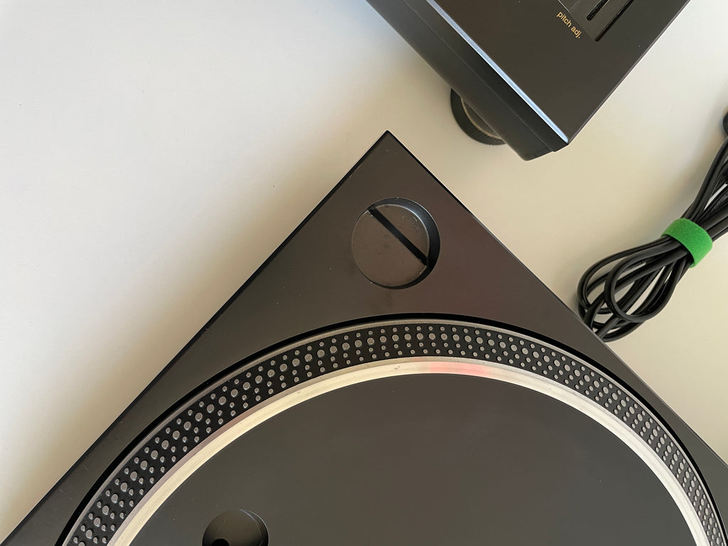 Close-up of a turntable with a cable on a light background