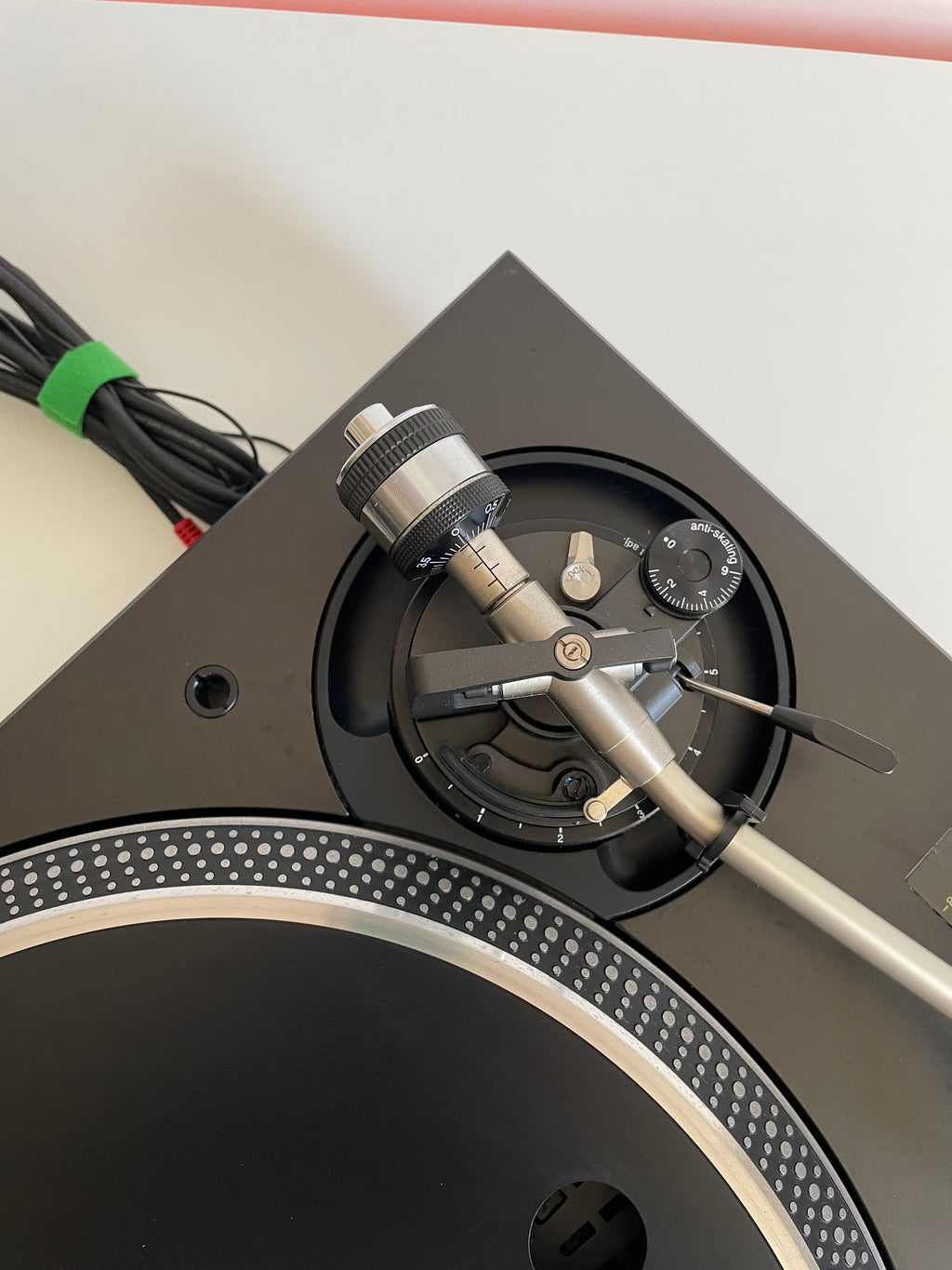 Close-up of a turntable with a needle on a white background