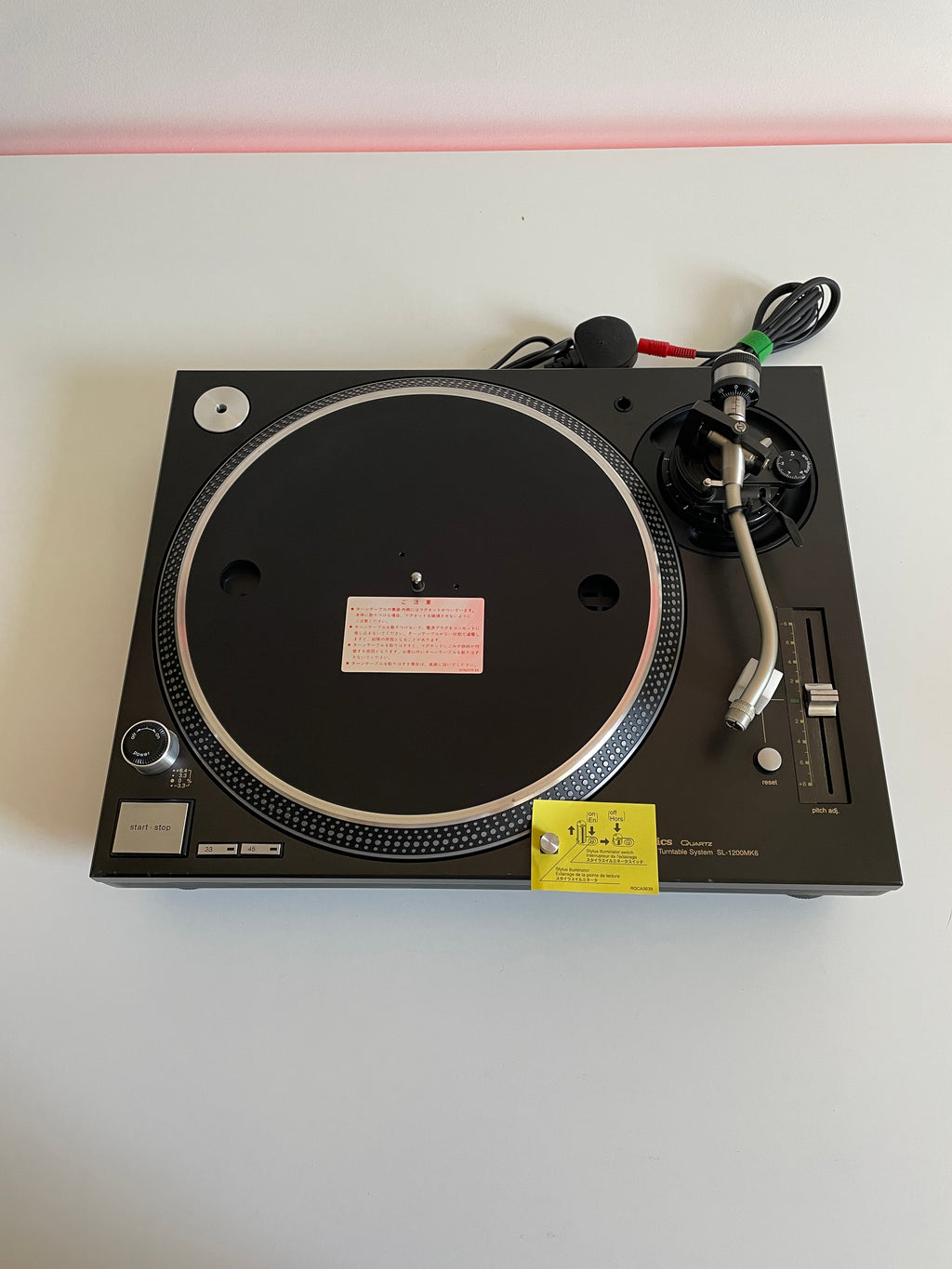 Black turntable with a record on a white background