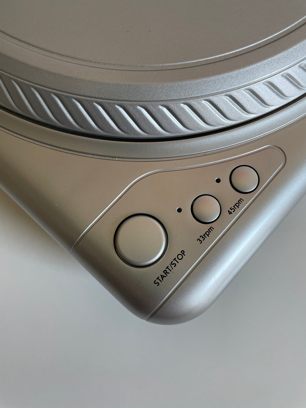 Close-up of a silver electronic device with control buttons on a light gray background