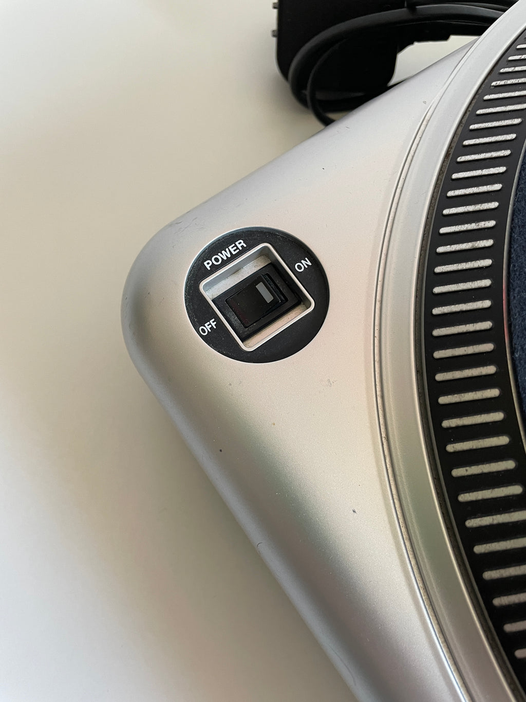 Close-up of a silver appliance with a control knob on a light gray background