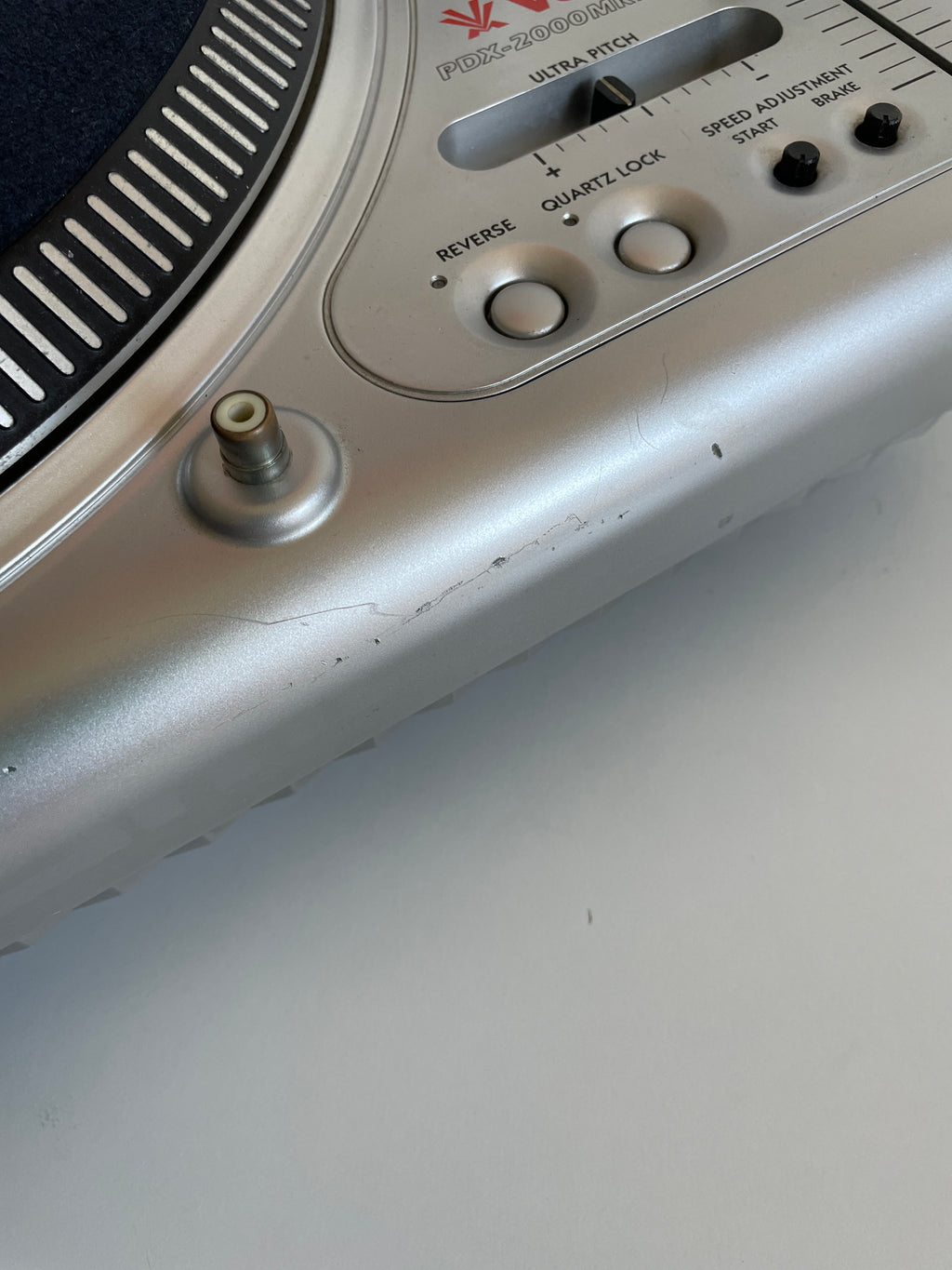Close-up of a vintage record player with control knobs and dial on a plain background