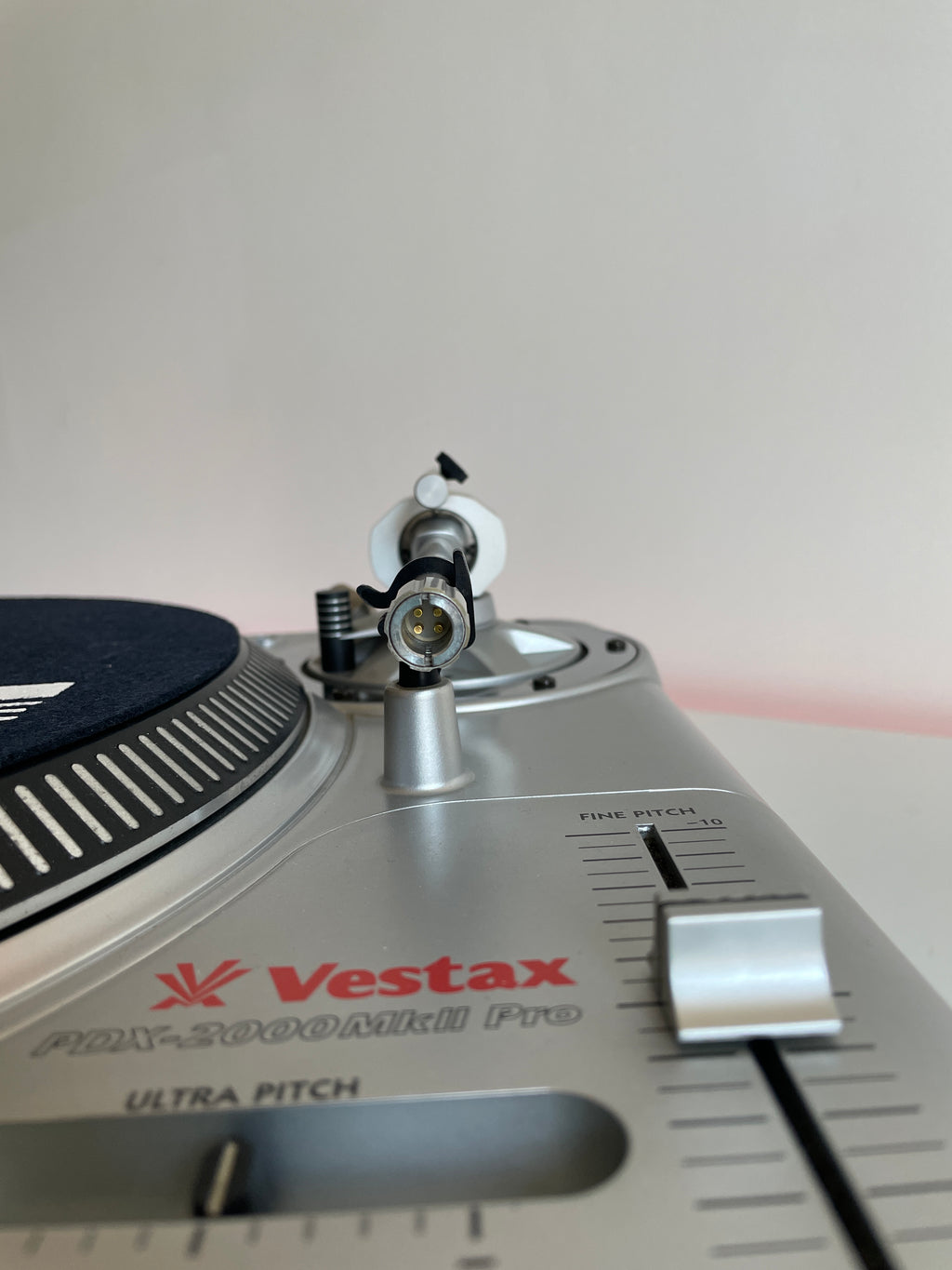 Close-up of a Vestax turntable needle on a gray background