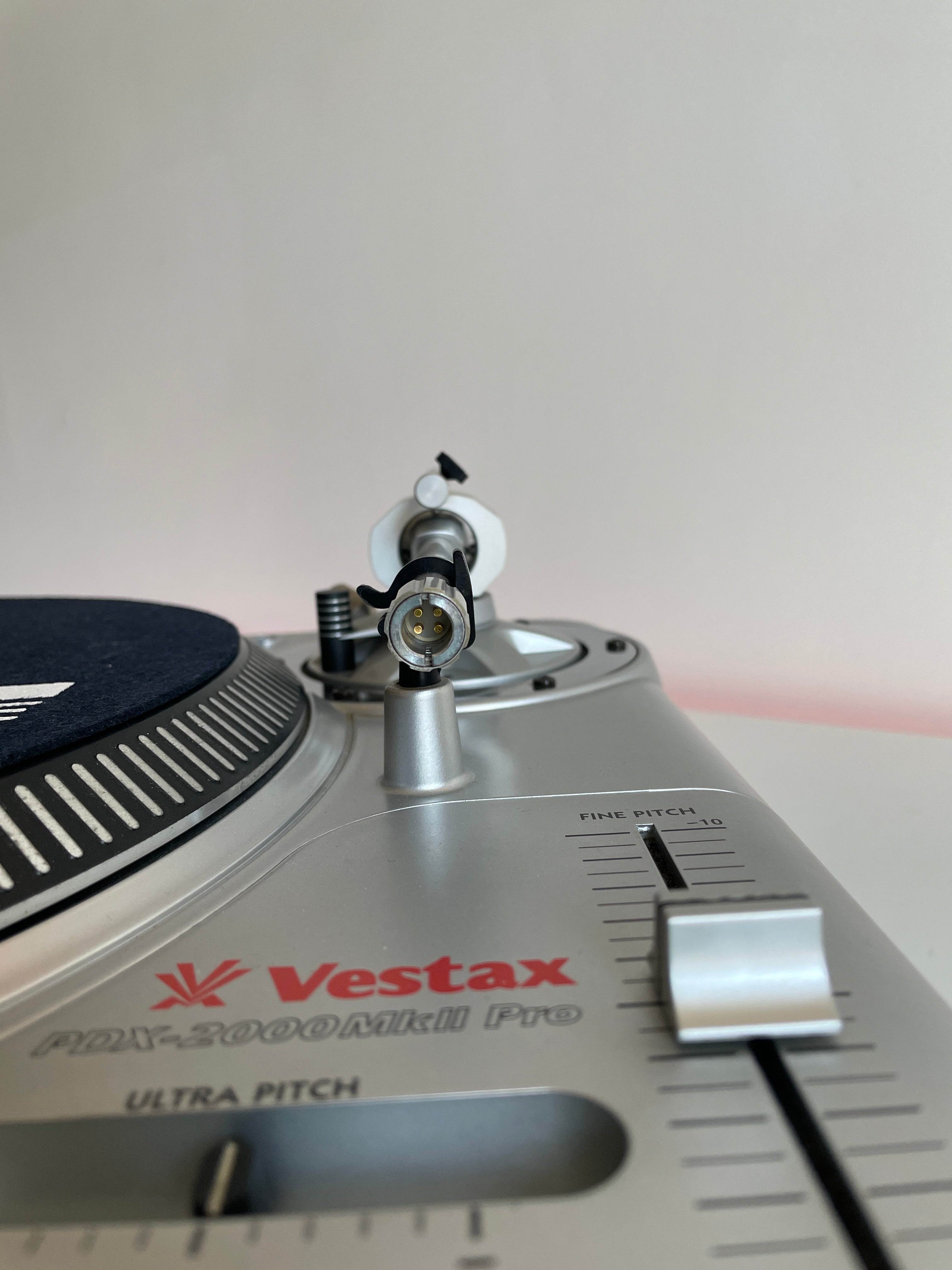 Close-up of a Vestax turntable needle on a gray background