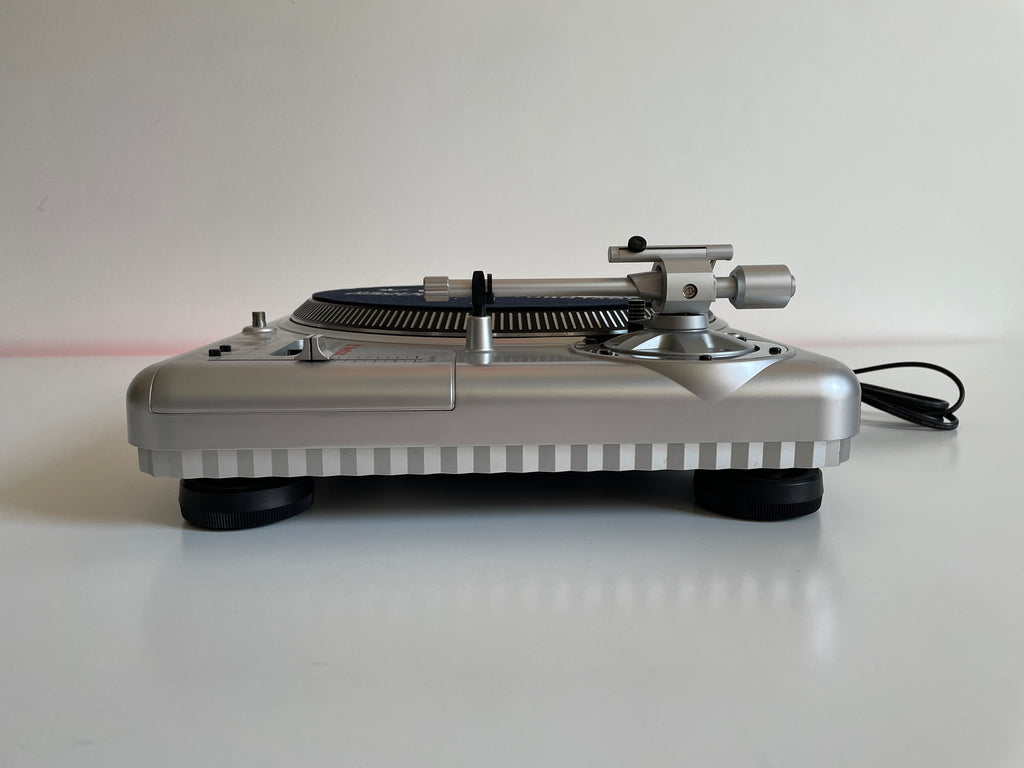 Silver turntable on a white surface with a plain background