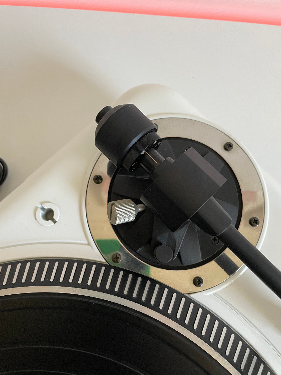 Close-up of a turntable with a focus on the cartridge and tonearm.