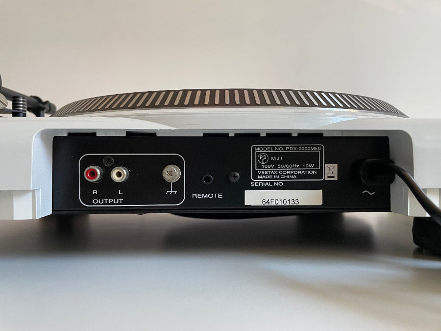 Back view of a turntable with audio connectors on a white background