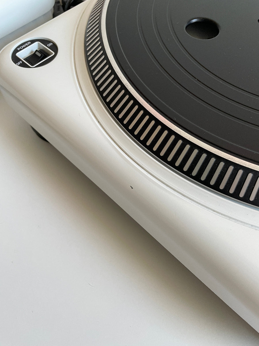 Close-up of a turntable with a focus on the platter and tonearm.