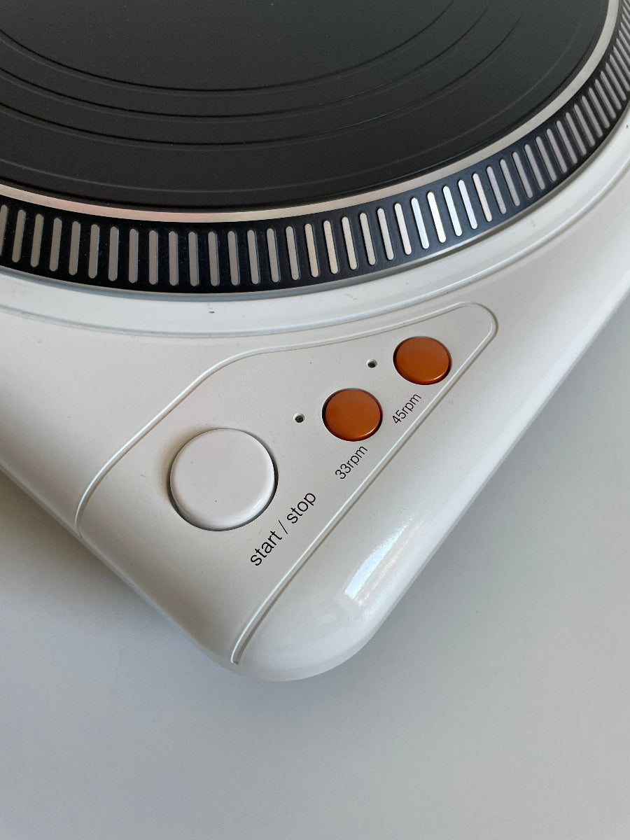 Close-up of a vintage turntable and control panel on a gray background